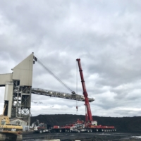 CCI Industrial Constructors - A red mobile crane operates amidst heavy machinery at a coal processing site under a cloudy sky.