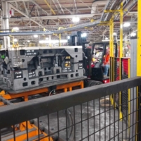 CCI Industrial Constructors - Forklift in action at an industrial manufacturing site, transporting heavy molds or equipment amidst a busy factory floor.