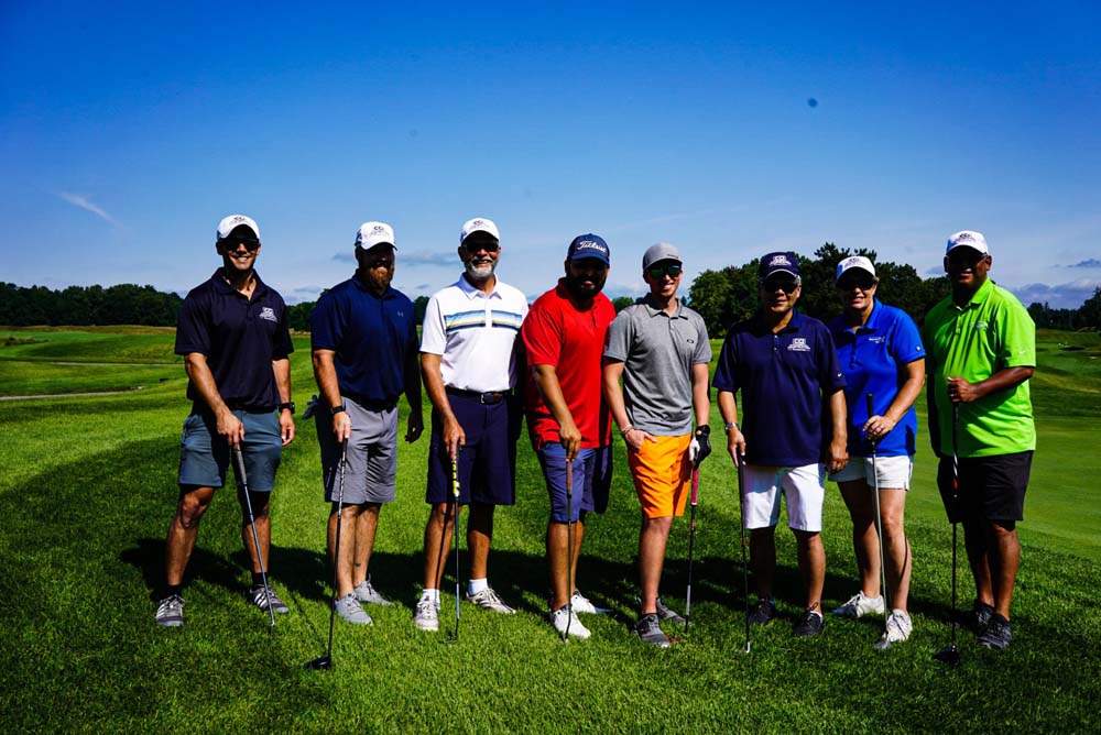 CCI Industrial Constructors - Group of golfers standing side by side on a golf course on a sunny day.