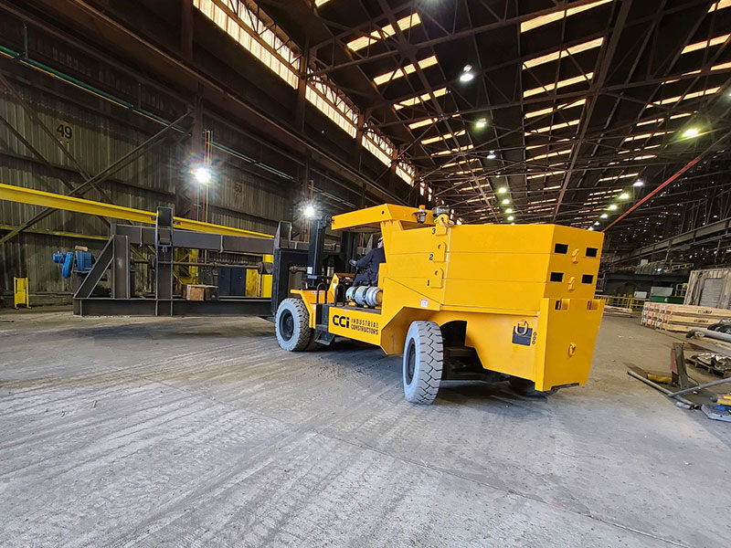 CCI Industrial Constructors - A large yellow industrial forklift inside a spacious warehouse, ready for heavy-duty lifting.