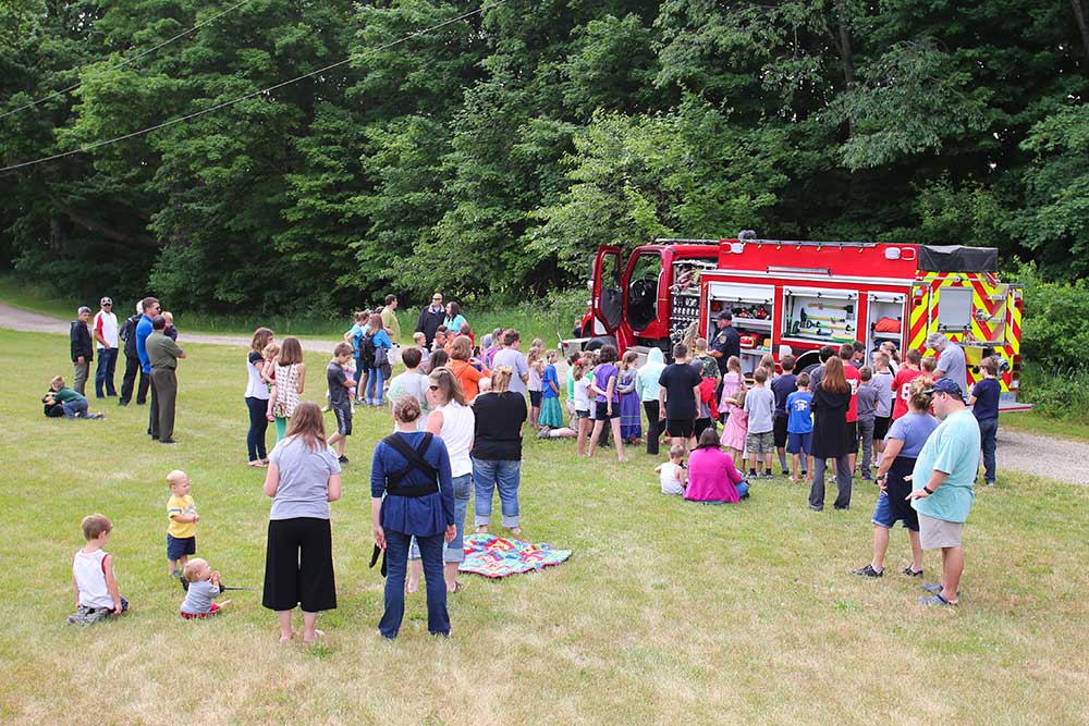 CCI Industrial Constructors - A community gathering with children and adults around a fire engine at a park.