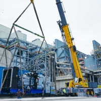 CCI Industrial Constructors - Installation of heavy industrial equipment using a large mobile crane at a manufacturing plant.