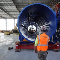 CCI Industrial Constructors - Workers inspecting a large industrial component, possibly part of a turbine or engine, in a manufacturing or assembly facility.