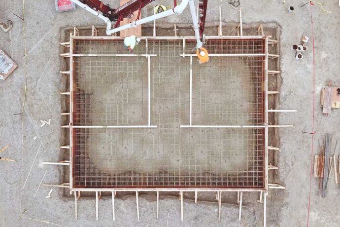 CCI Industrial Constructors - Aerial view of a construction site foundation with wooden formwork and steel reinforcement bars in place, ready for concrete pouring.